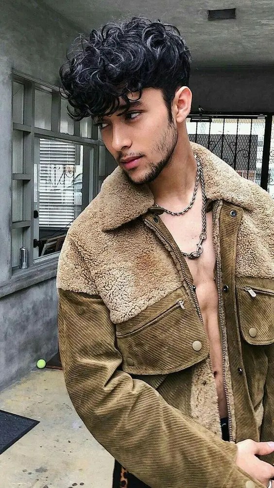 Man in corduroy jacket with curly hair