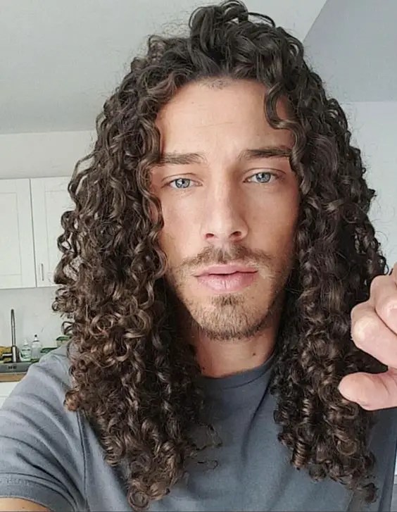 Man rocking brunette curly hairstyle for men