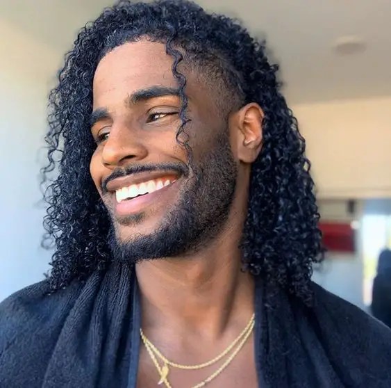 Black man smiling and showing curly hairstyle
