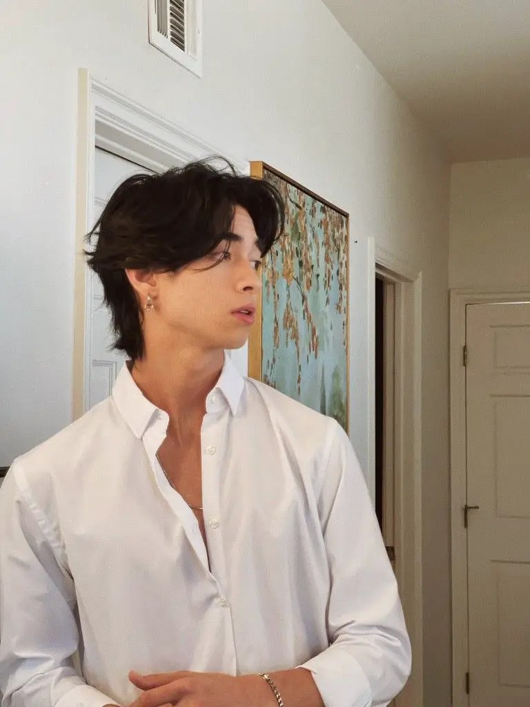 Sweet Asian man in white shirt showing his hairstyle