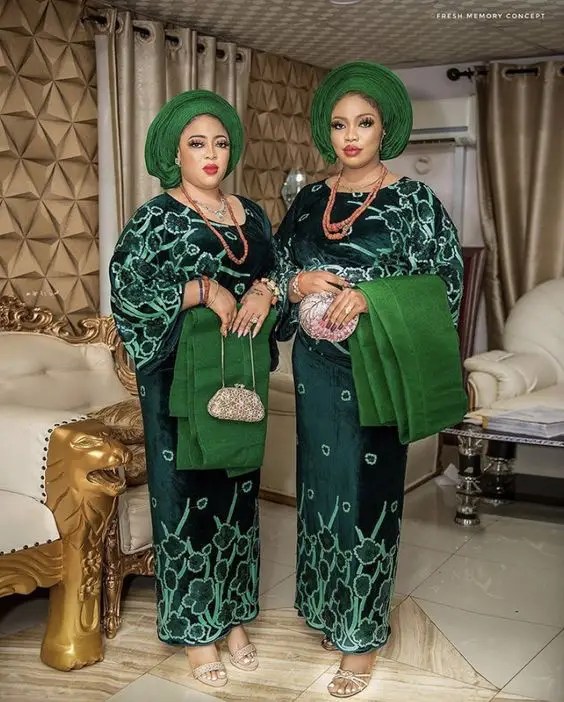 Two beautiful women dressed in green iro and buba as traditional African dresses