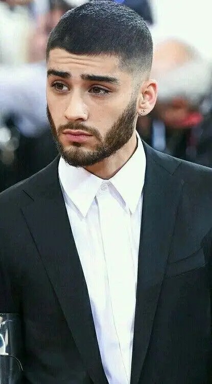 A man wearing a suit with a low-cut hairstyle
