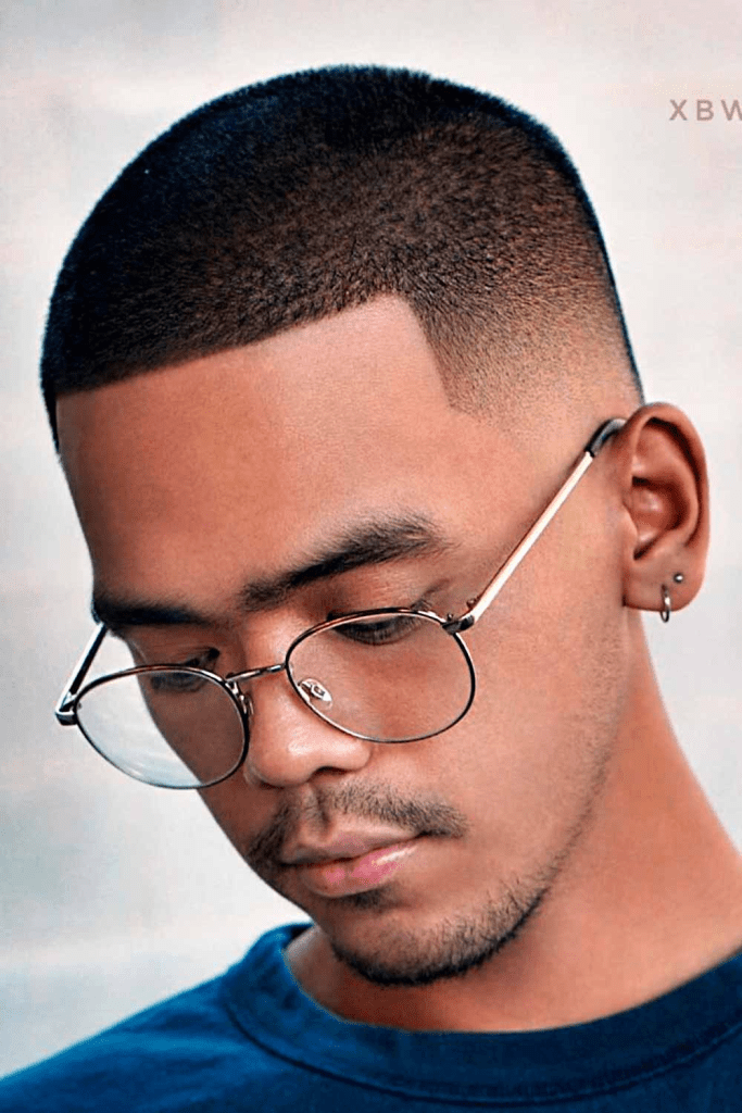 Man with glasses wearing buzz hairstyle with fade