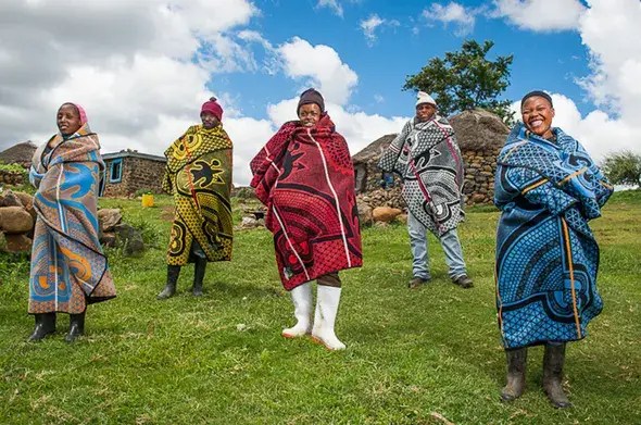 Five people dressed in traditional Soto African costumes