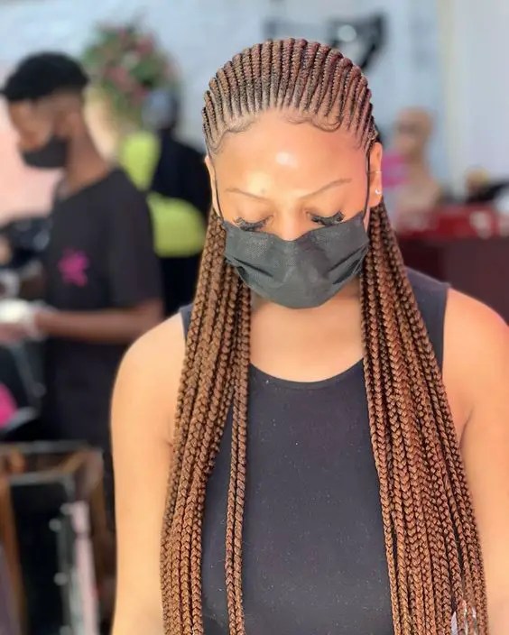 Woman with face mask wearing full cornrow ghana weave style