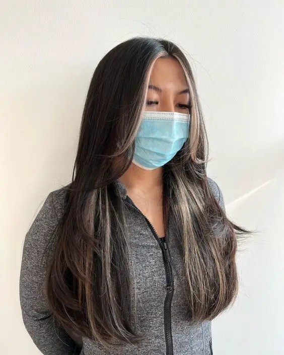 Woman in face mask rocking straight-cut feathery layers