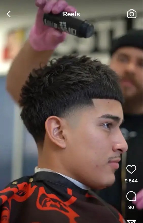 Man sitting at the barbershop and flaunting his hairstyle