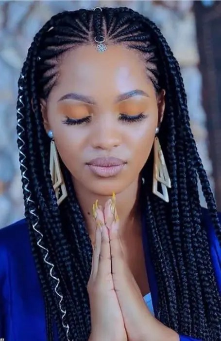 Woman closing her eyes in prayer while rocking her tribal braid