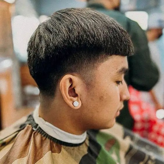 Man with studs showing profile of haircut