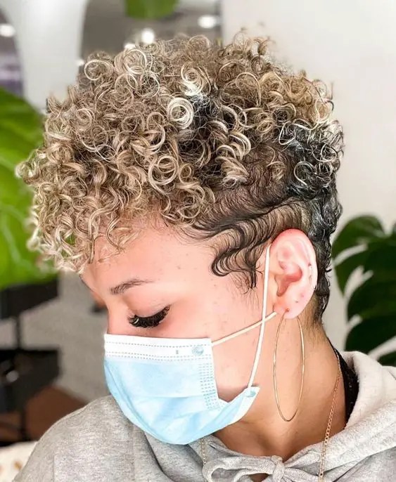 Woman wearing face mask and showing off short curls