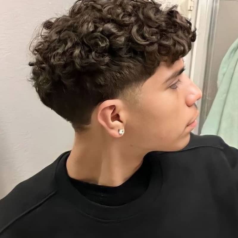 Side view of man rocking curly bird's nest hairstyle