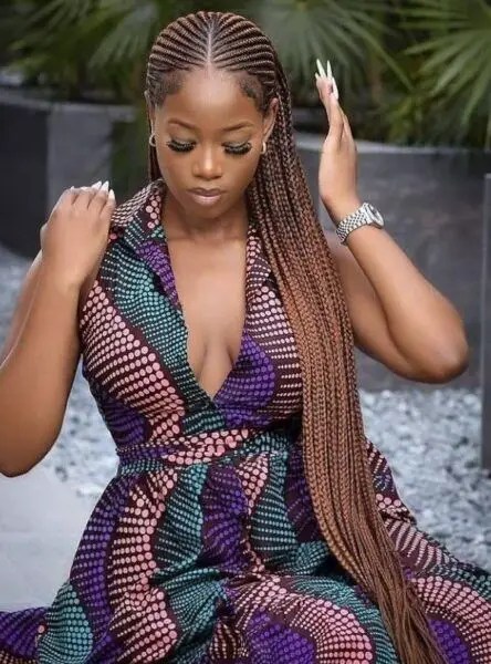 Woman wearing waist length ghana weave style