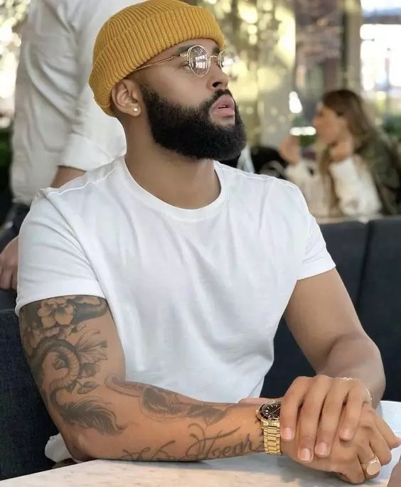 Handsome man with glasses wears a white t-shirt with a beard.
