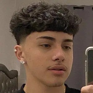 A man wearing studs and showing his fluffy hair