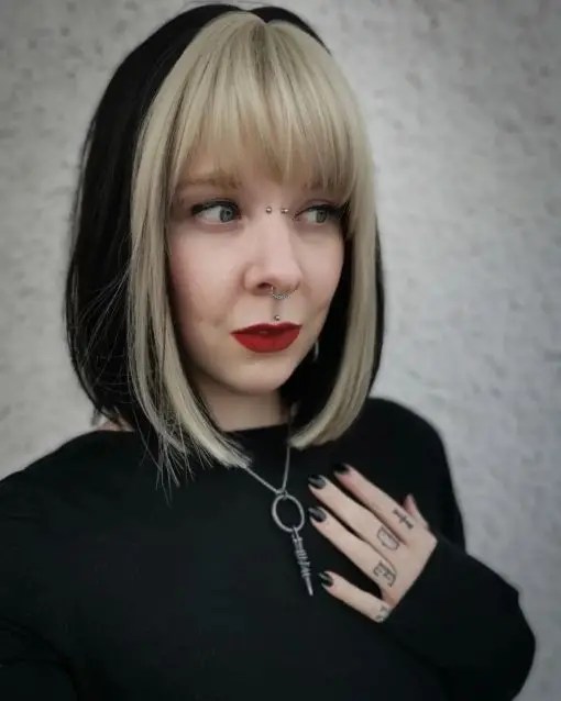 Caucasian woman wearing dark hair and blonde bangs