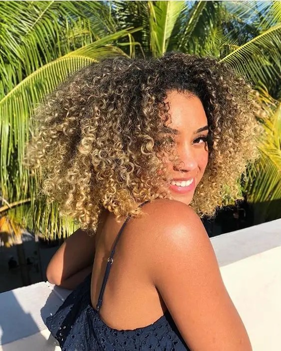 Woman smiling and showing curly curly hair