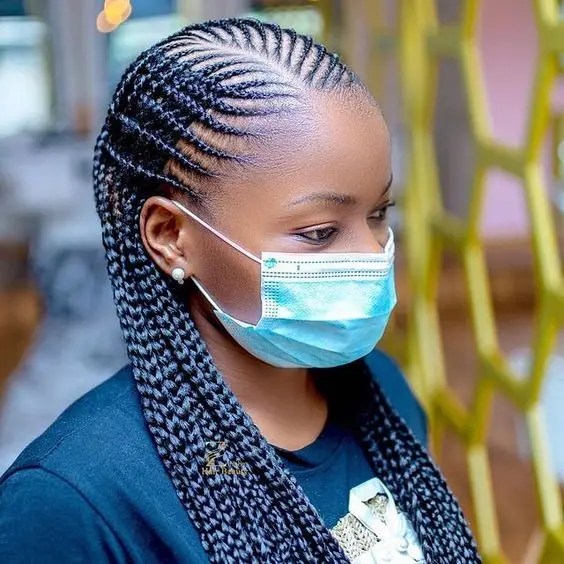 Masked woman rocking side parted Ghanaian braids