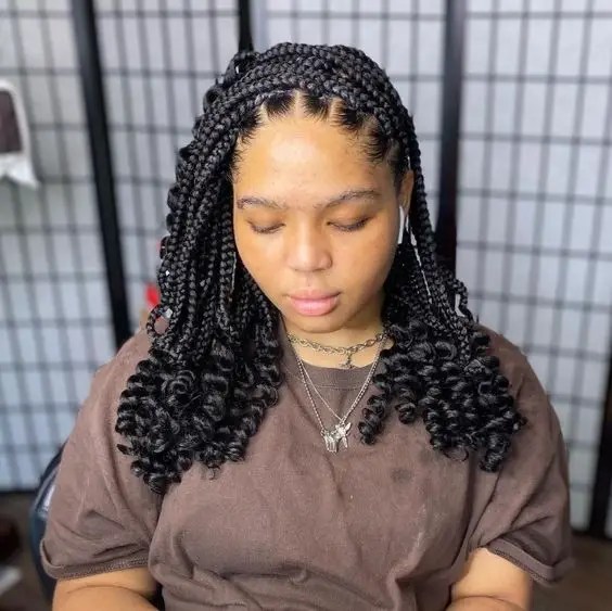 Woman wearing curly thick medium braids