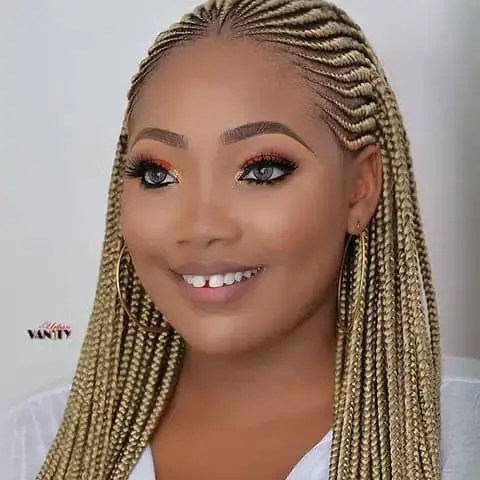 smiling woman rocking gold ghana weave style