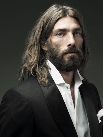 A man with long hair shows off his full neck beard