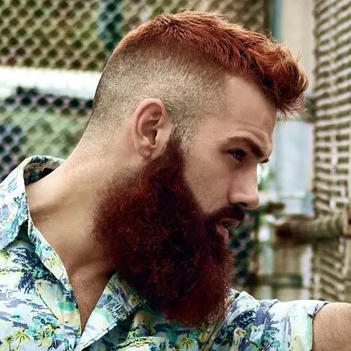Profile of a man rocking a full burgundy beard