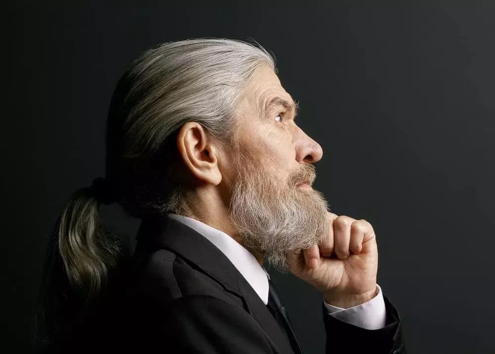 A man with a wavy beard and a ponytail.