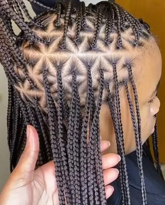 Profile of a woman rocking braids in a triangular parting