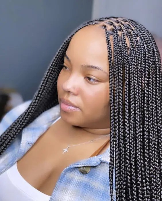 Women show off small knotless braids in the middle part