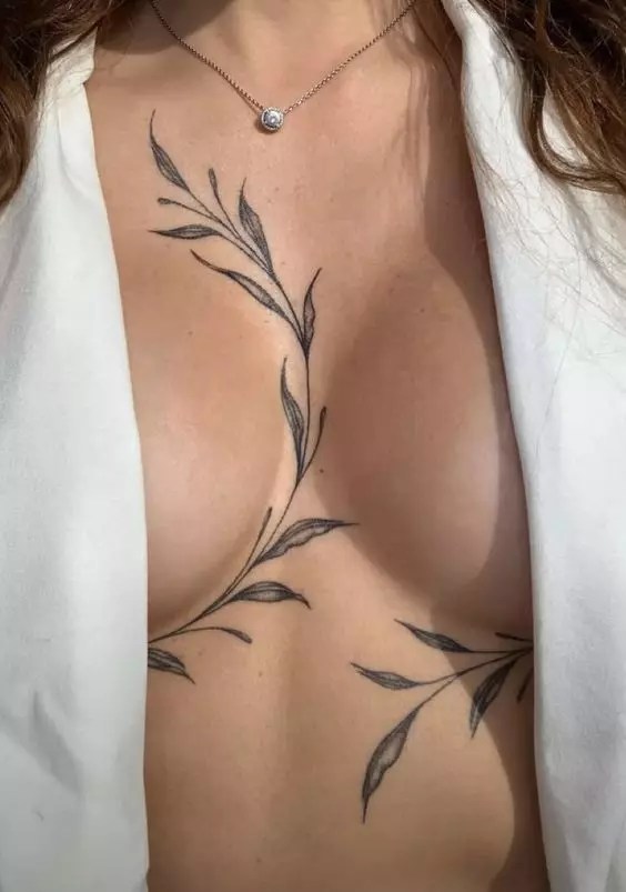 A beautiful floral sternum tattoo runs across the chest.