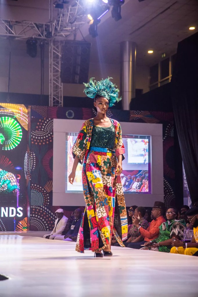 Model rocking long cape with Ankara print and hat at Uyo Fashion Week