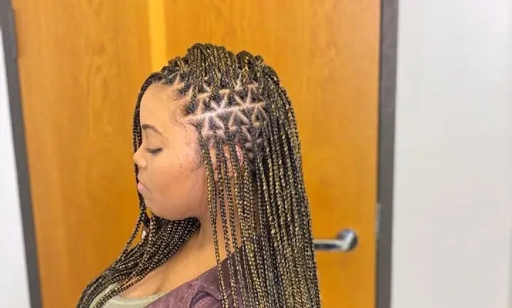 The lady rocks a small knotted braid that is divided into triangular sections.