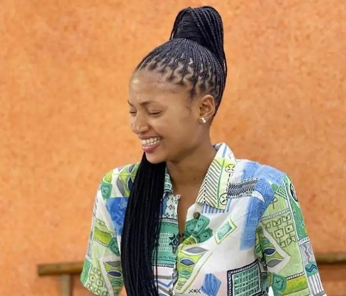 The woman wraps her gorgeous braids in a high ponytail.