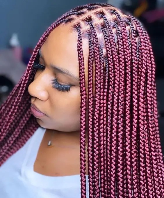 Gorgeous profile of a woman rocking red knotless braids
