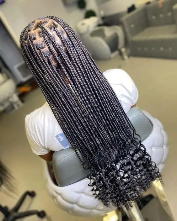 Rear view of a woman rocking a medium knotless braid with curls at the ends