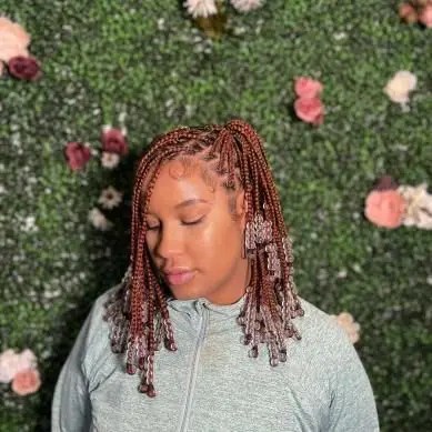 Cute little girl rocking short little knotless braids with beads
