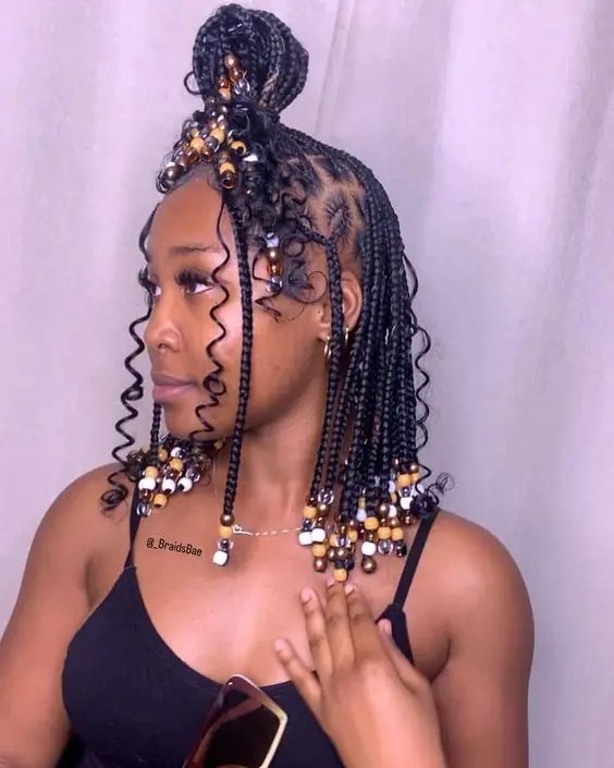Pretty woman looking to the side showing her beaded knotless braids