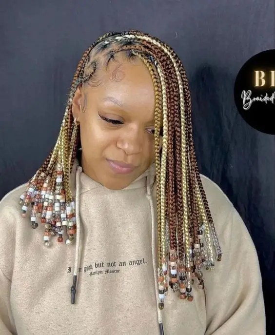 A woman swinging three-color braids with beads