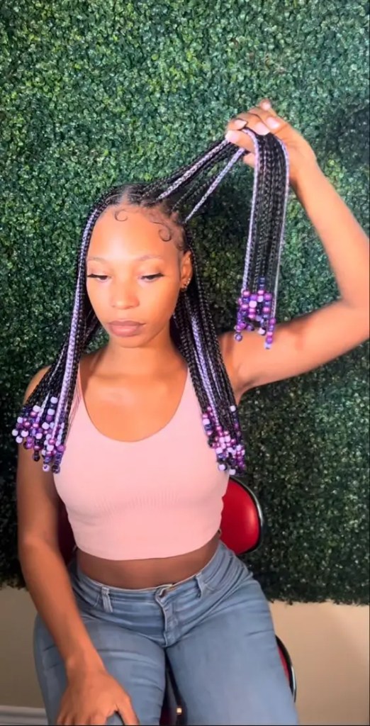 Woman braided with various shades of purple beads