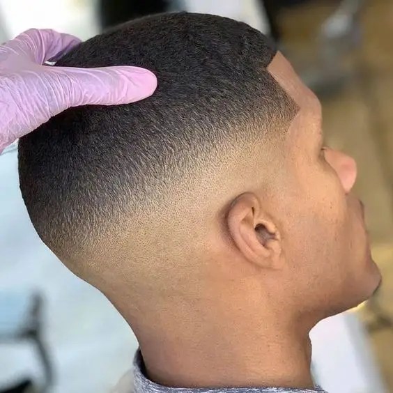 Stylists show off a well-groomed mid-fade haircut.