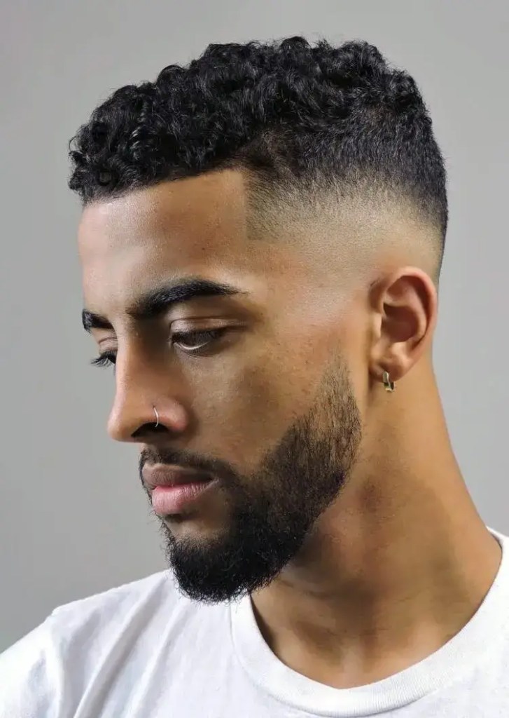 Man shows off curly hair combined with mid-fade haircut