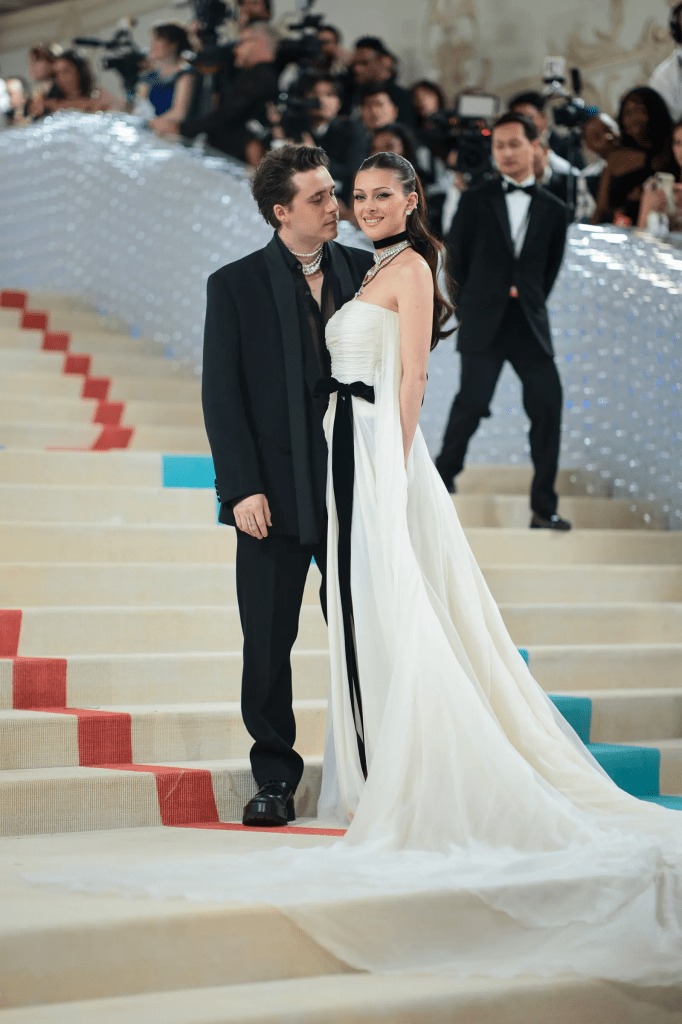 Nicola Peltz and husband Brooklyn Beckham add weight to the necklace, Peltz in a strapless ruffled ivory gown adorned with a black velvet bow, tied at the waist and with a matching choker. shook the