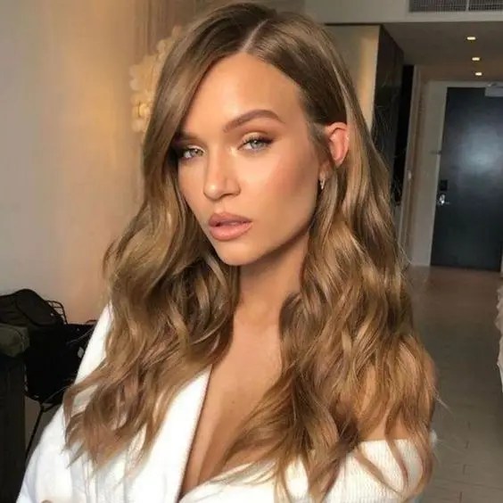 Honey blonde hair parted to the side.