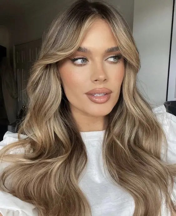 Woman with beautiful dirty blond hair, middle part with bangs