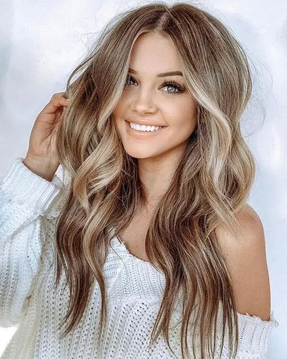 Gorgeous woman shows off long wavy hair with platinum highlights