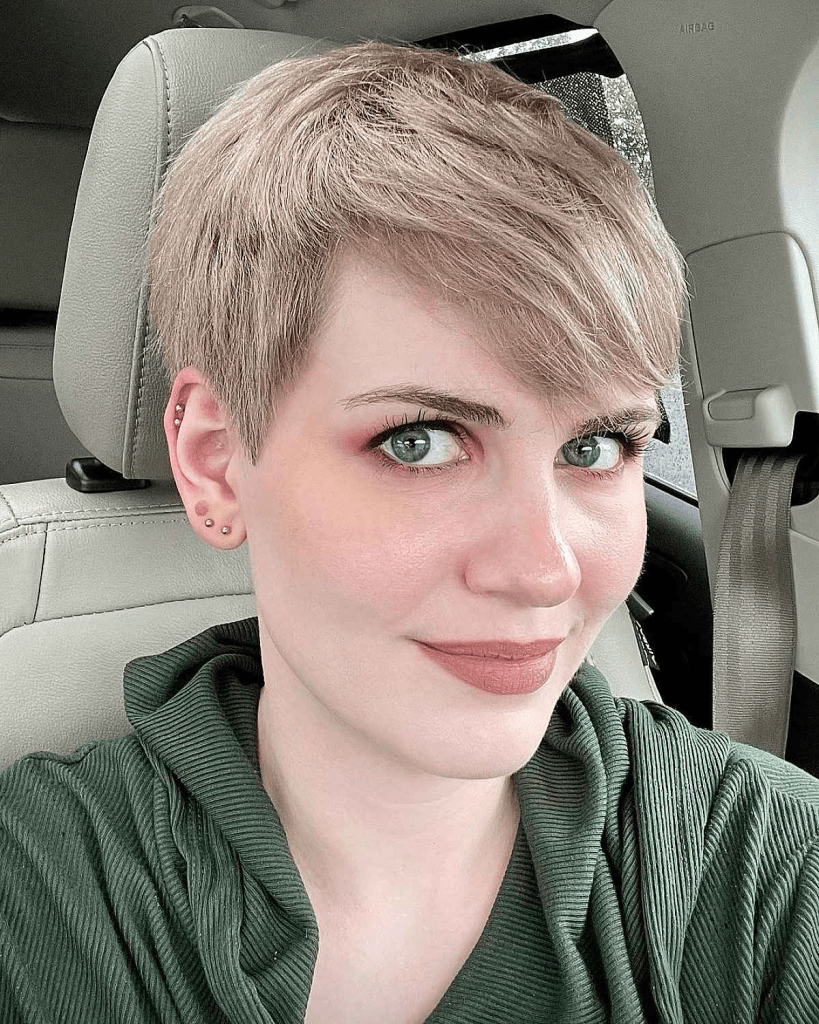 A beautiful woman shows off her messy blonde pixie cut.