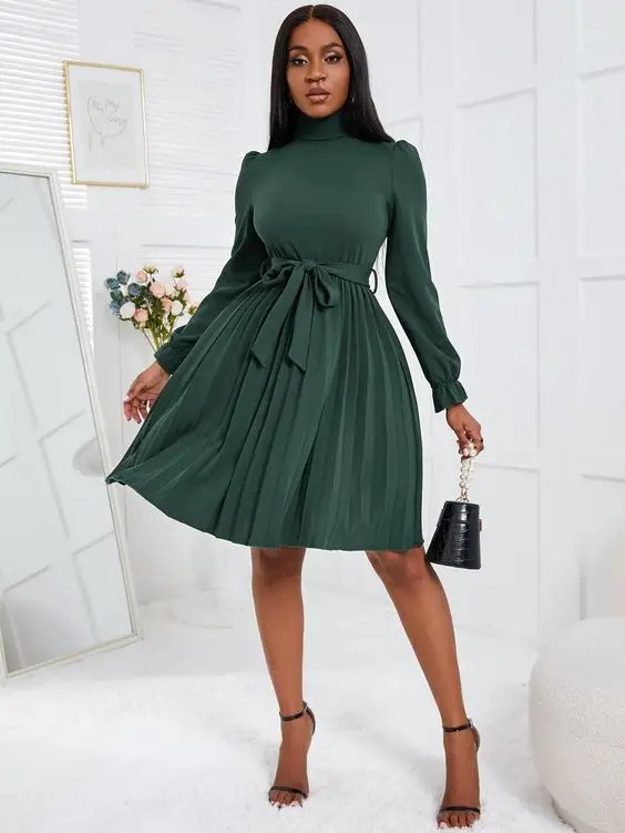 Pretty woman in dark green dress with black handbag