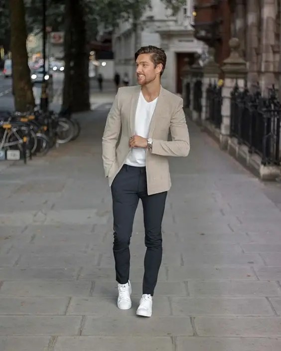 A man wearing sneakers with a blazer outfit