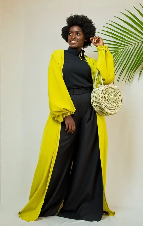 Smiling woman in black and yellow clothes holding a woven bag