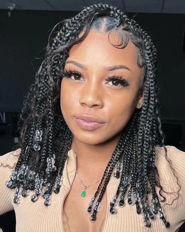 Cute little girl rocking a knotless braid with beads and curls