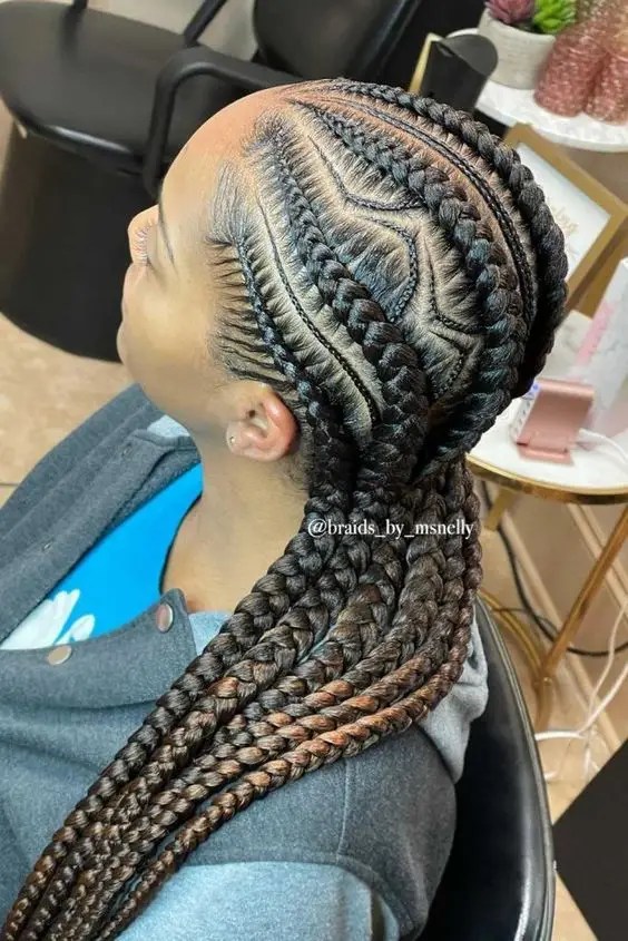 A woman rocks her unique stitched braids and shows them off without looking at the camera